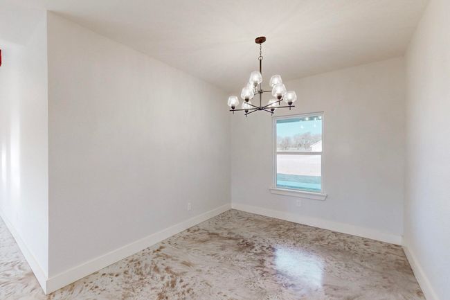 Empty room with baseboards and an inviting chandelier | Image 18