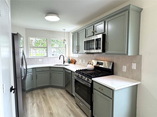 Quartz counters, tile backsplash, Black pull down faucet, Updated lighting, &New Gas Range | Image 4