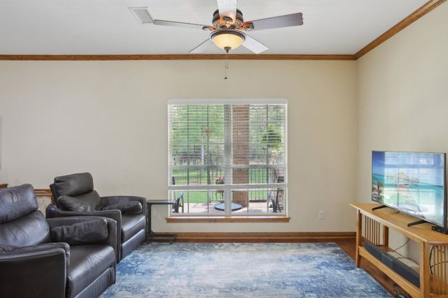 Living room with baseboards, ornamental molding, wood finished floors, and ceiling fan | Image 9