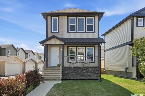 Two-story residence featuring light-colored siding with dark trim accents | Card Image