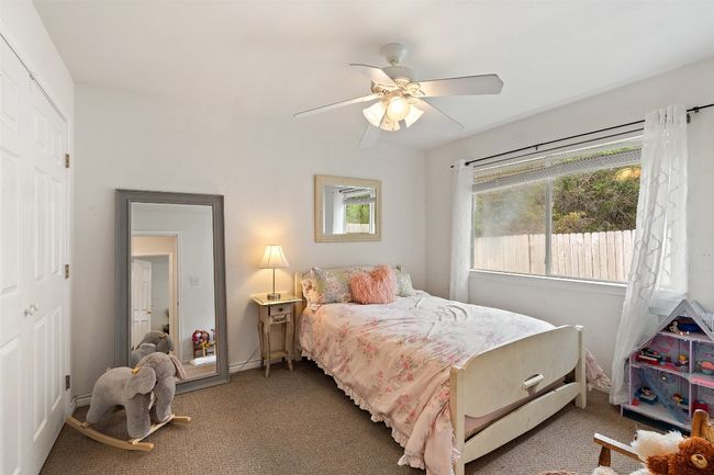 Carpeted bedroom with a ceiling fan and baseboards | Image 32