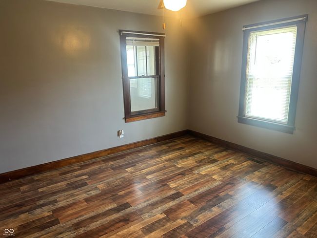 empty room featuring baseboards, a ceiling fan, visible vents, and dark wood-style floors | Image 8