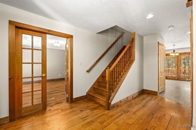 Stairs with wood-type flooring, a textured ceiling, and french doors | Image 28