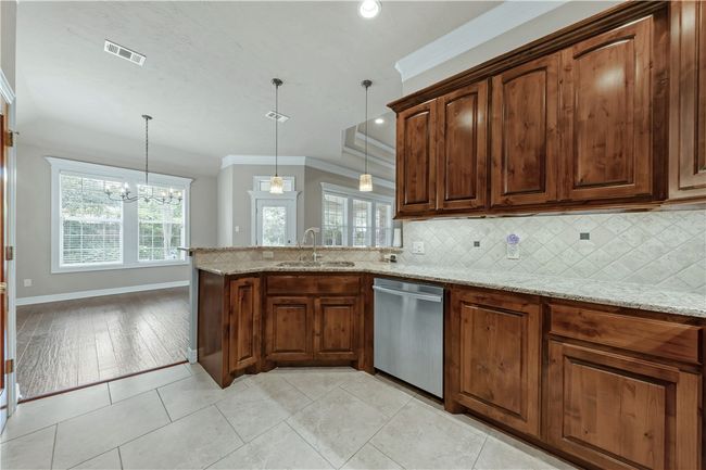 Kitchen with dishwasher, a sink, tasteful backsplash, ornamental molding, and baseboards | Image 16