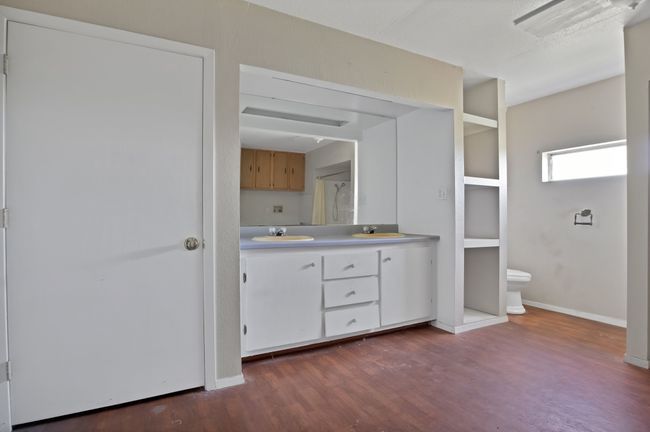 Full bath with double vanity, wood finished floors, baseboards, and toilet | Image 23