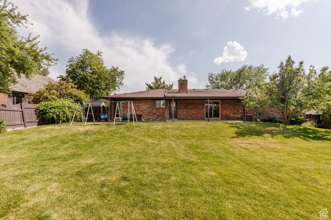 Back of property featuring a playground, a chimney, and brick siding | Image 39