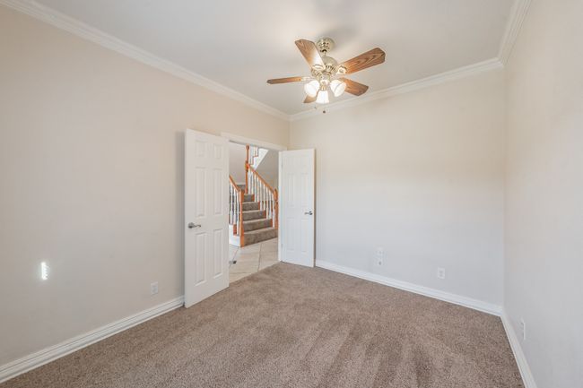 Unfurnished room featuring light carpet, ceiling fan, and ornamental molding | Image 5