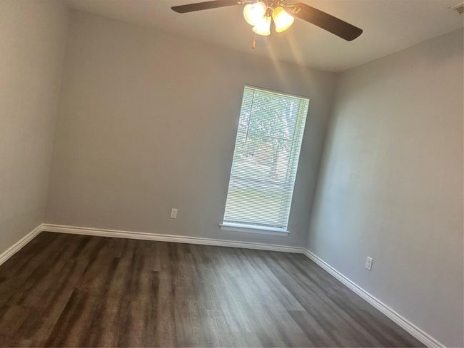 Unfurnished room featuring baseboards, a ceiling fan, and dark wood-style flooring | Image 7