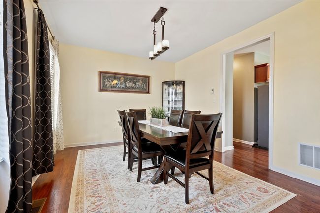 The dining room includes large windows and custom lighting. | Image 12