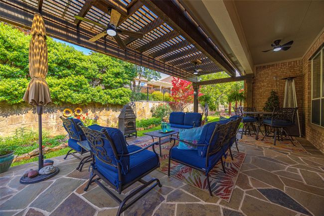 Fenced backyard featuring a pergola, an outdoor hangout area, ceiling fan, perfect for relaxing and entertaining. | Image 27