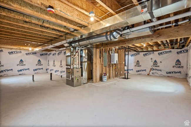 Unfinished basement featuring heating unit and tankless water heater | Image 47