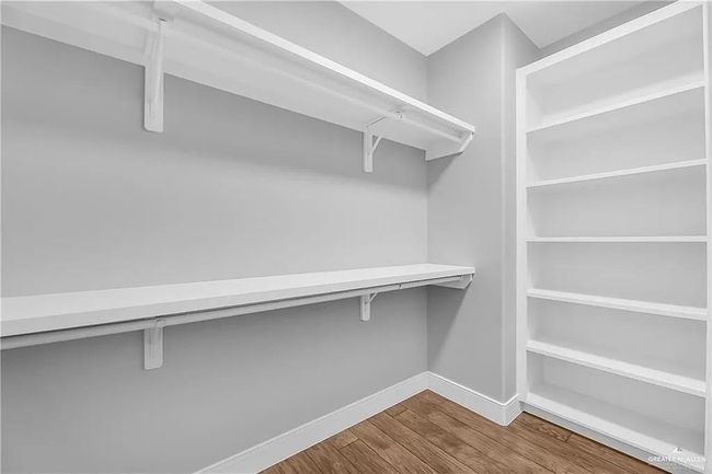 Spacious closet featuring dark wood finished floors | Image 14