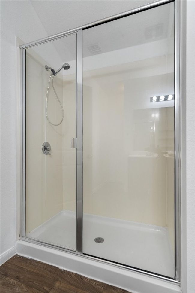 Full bathroom featuring a stall shower, wood finished floors, and baseboards | Image 16