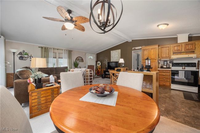 Dining space with a ceiling fan, ornamental molding, and a chandelier | Image 22