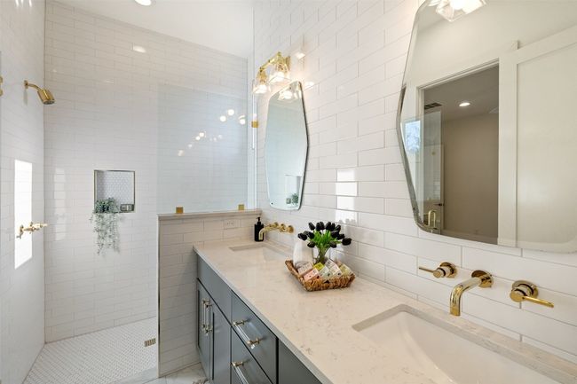 Full bathroom featuring tile walls, a walk in shower, double vanity, and a sink | Image 29