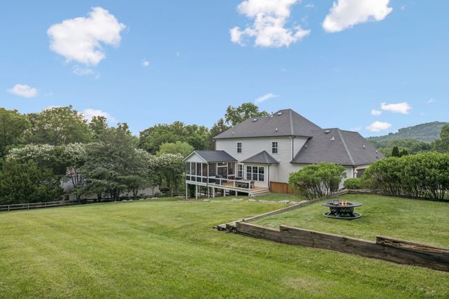 Gorgeous rear elevation showcasing both deck and screened porch overlooking the expansive fenced yard. | Image 24