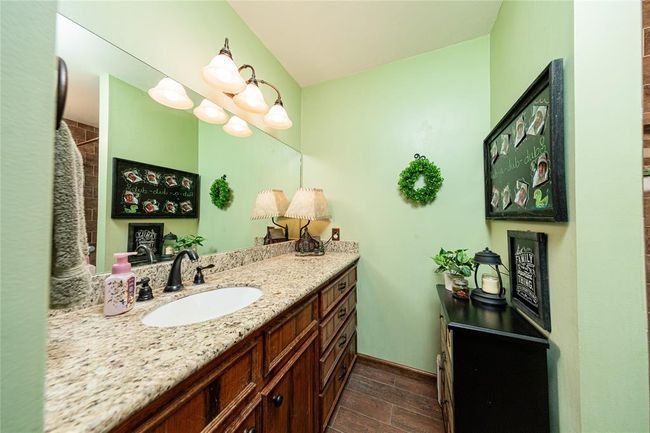 Granite counters, new tile work and updated light fixtures have been installed in the secondary bathroom. | Image 18