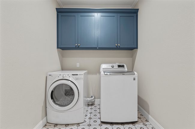 Washroom with separate washer and dryer, baseboards, ornamental molding, and cabinet space | Image 27