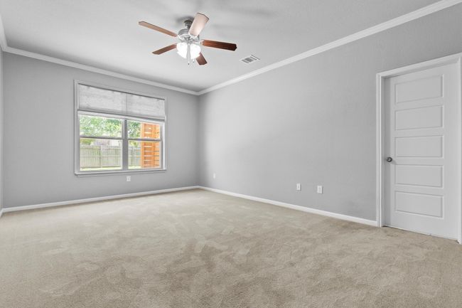 Carpeted spare room featuring ornamental molding, ceiling fan, and baseboards | Image 31