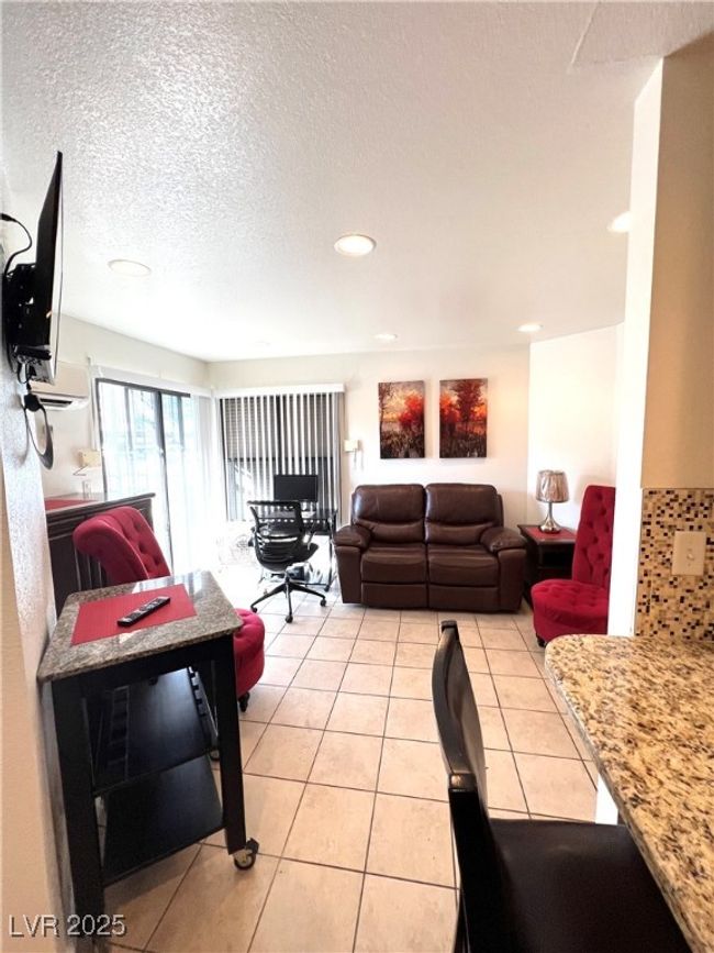 Living area with light tile patterned floors, recessed lighting, and a textured ceiling | Image 7