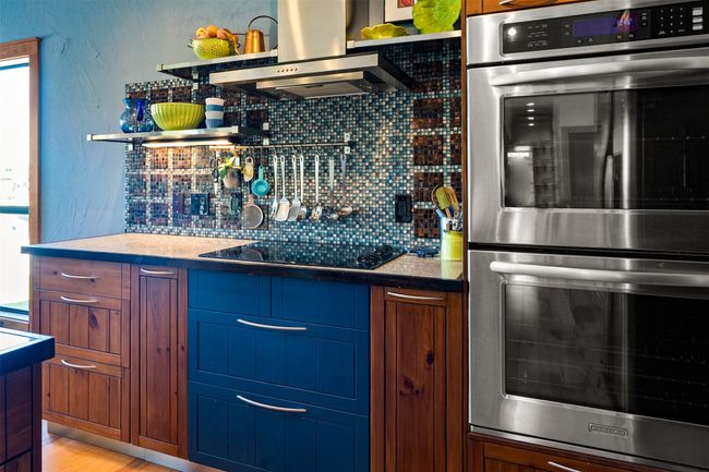 Kitchen with tasteful backsplash, double oven, wall chimney exhaust hood, and black electric stovetop | Image 15