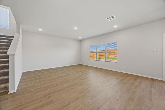 Unfurnished room with wood finished floors, recessed lighting, and stairway | Image 4