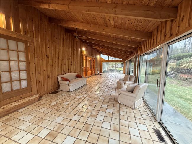 Unfurnished sunroom with visible vents and beam ceiling | Image 8