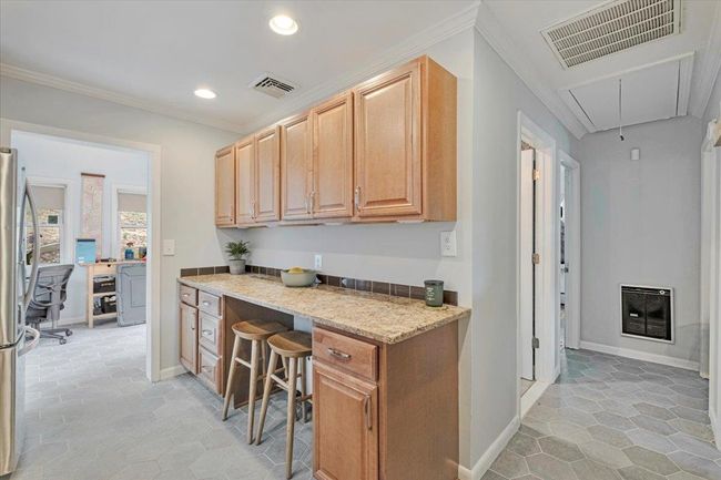 Kitchen with built in study area, heating unit, crown molding, and visible vents | Image 7