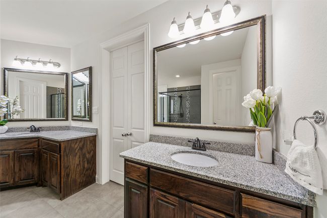 Bathroom with two vanities, tile patterned floors, and a shower | Image 23
