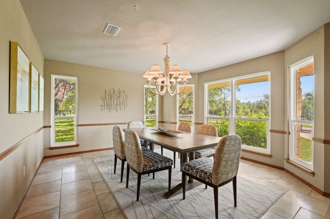 Dining room featuring a chandelier and light tile patterned floors | Image 8