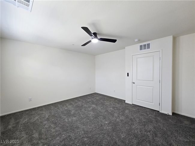 Spare room featuring dark colored carpet, ceiling fan, baseboards, and a smoke detector | Image 30