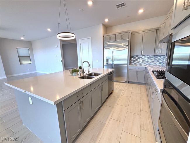 Kitchen with a sink, visible vents, gray cabinetry, light countertops, and stainless steel appliances | Image 14