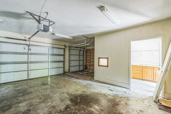 Garage featuring a garage door opener and wooden walls | Image 31
