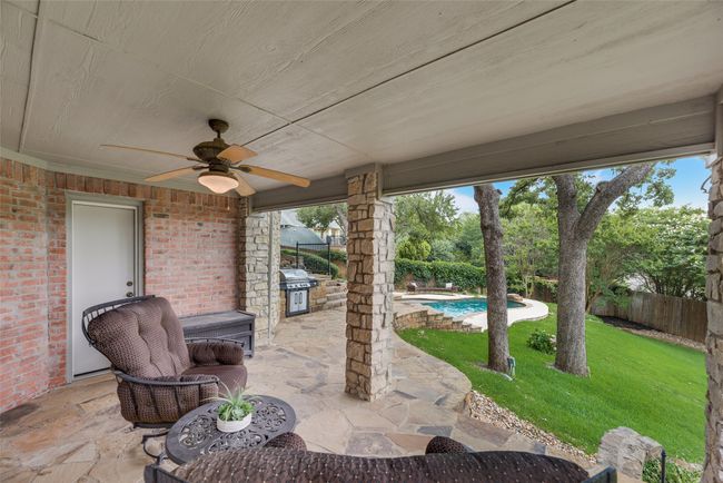 Double doors from basement lead to this large covered patio great for entertainment as it seamlessly joins the outdoor living space and pool with the basement. | Image 31