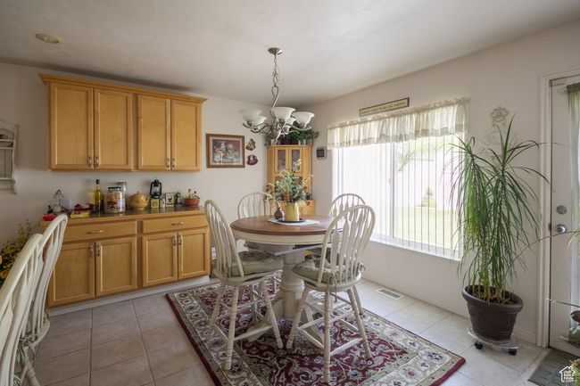 Dining space featuring visible vents, light tile patterned floors, and a notable chandelier | Image 6