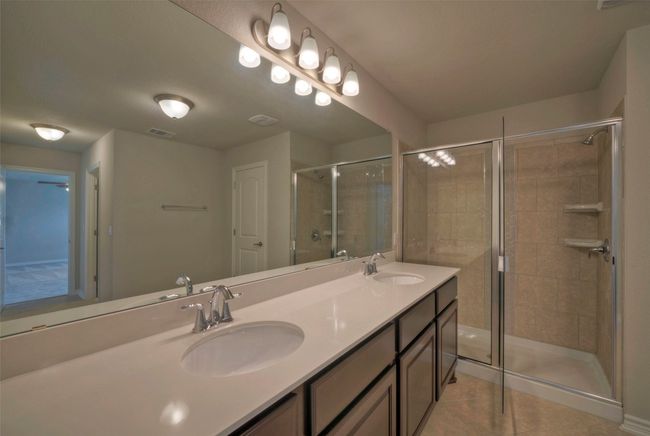 Bathroom featuring a stall shower, visible vents, tile patterned flooring, and a sink | Image 20