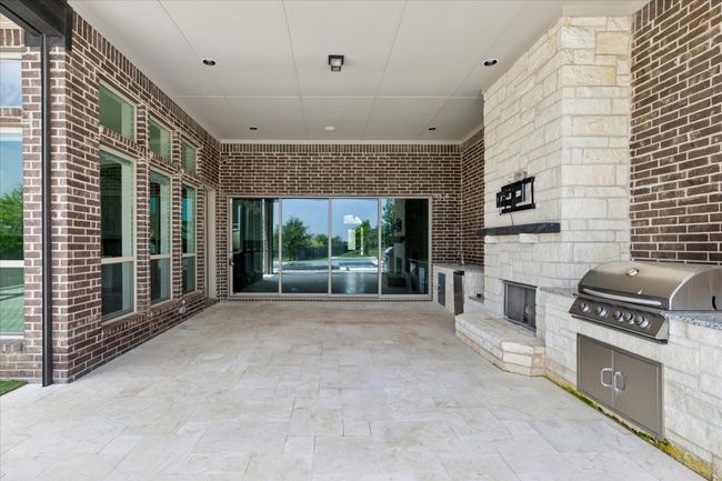 Outdoor living area with fireplace, kitchen with sink, BBQ grill area, and equipped with surround sound. Perfect for entertaining. Also, there is a remote-controlled screen that comes down on the 2 open sides. | Image 37