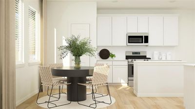 Kitchen with light wood-type flooring, plenty of natural light, white cabinetry, and stainless steel range | Image 2