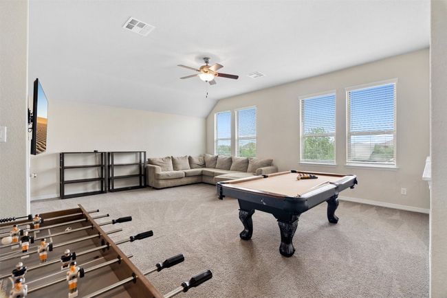 The upstairs game room is a spacious, versatile area perfect for entertaining or movie nights | Image 23