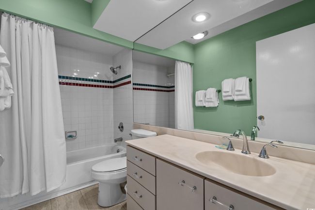 Bathroom with shower / bath combination with curtain, toilet, and vanity | Image 28