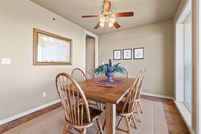 Dining room with a ceiling fan, baseboards, and tile patterned floors | Image 9