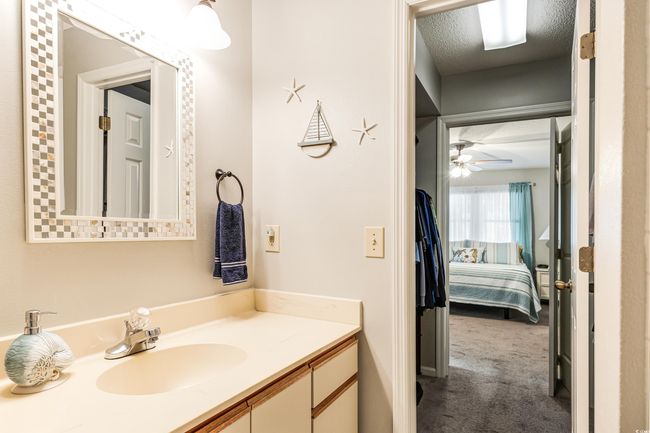 Bathroom with a ceiling fan, vanity, and a textured ceiling | Image 13