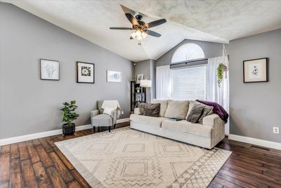 Living room with vaulted ceiling, a textured ceiling, dark hardwood / wood-style floors, and ceiling fan | Image 3