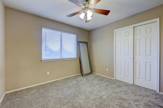 Unfurnished bedroom with carpet flooring, a closet, and a ceiling fan | Image 16