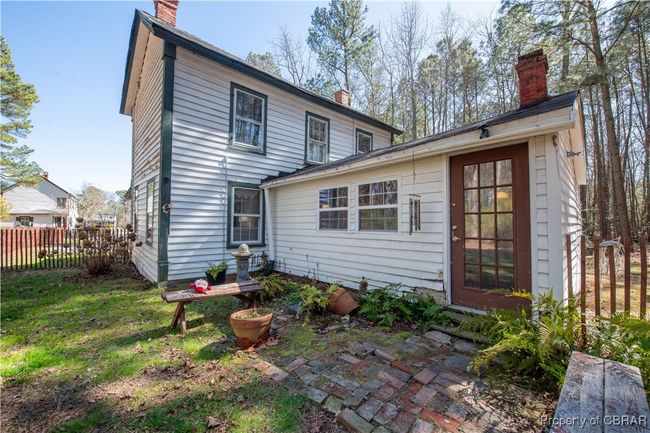 Back of house with a chimney, a yard, and fence | Image 18