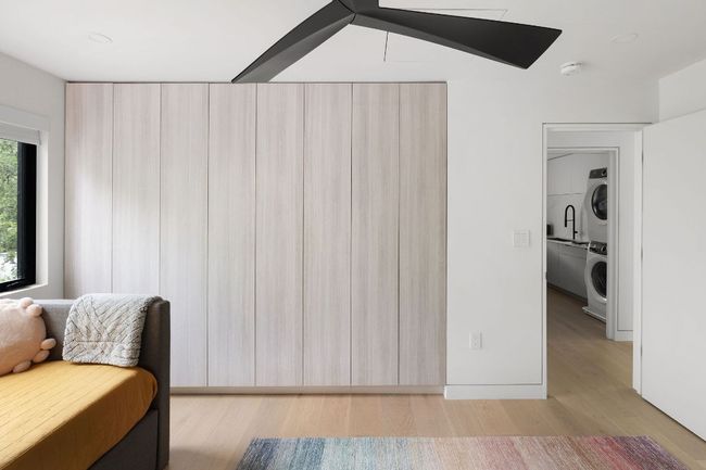 Sitting room featuring stacked washer and clothes dryer and light wood finished floors | Image 23