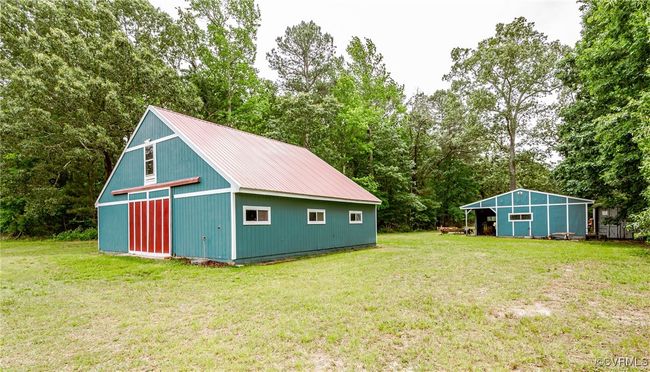 View of pole building featuring a lawn and view of wooded area | Image 39