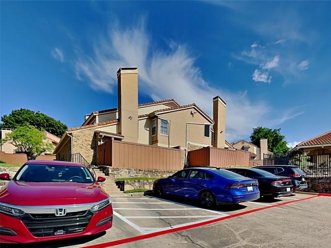 View of front facade with stone siding, a chimney, and uncovered parking | Image 22