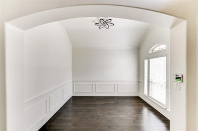 Spare room with crown molding, dark hardwood / wood-style floors, and vaulted ceiling | Image 3