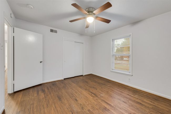 Unfurnished bedroom featuring baseboards, visible vents, wood finished floors, a closet, and ceiling fan | Image 12